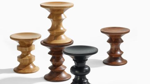 Five Eames Turned Stools in different shapes, two in white oak, two in walnut, and one in ebonized ash.