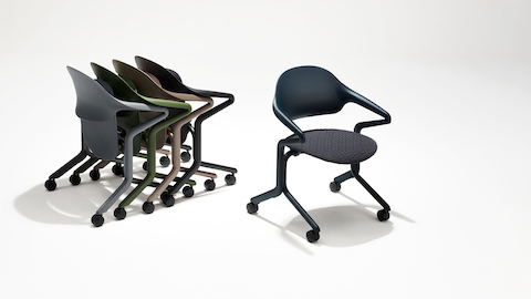 Four Fuld Nesting Chairs in various colors and finishes in a group next to a single Fuld Nesting Chair in Nightfall with a knit seat.