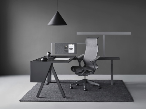 A Canvas Vista workstation in black and gray with a dark gray Cosm office chair. A Canvas Vista workstation in black and gray with a dark gray Cosm office chair.