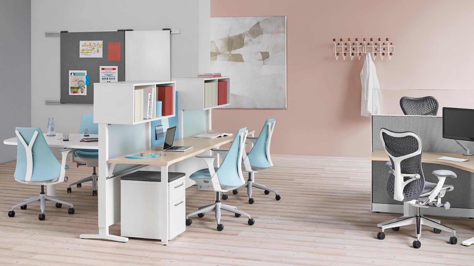 An open healthcare administrative area featuring light blue Sayl Chairs and gray Mirra 2 Chairs. Select to go to the Clinical products page.