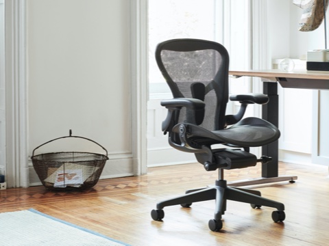 Aeron Chair in Graphite seen at an angle in front of a Renew Sit-to-Stand Desk in a home office setting. Aeron Chair in Graphite seen at an angle in front of a Renew Sit-to-Stand Desk in a home office setting.