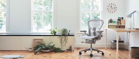 Aeron Chair in mineral seen from the front next to an Everywhere Table in a brightly lit home setting. Aeron Chair in mineral seen from the front next to an Everywhere Table in a brightly lit home setting.